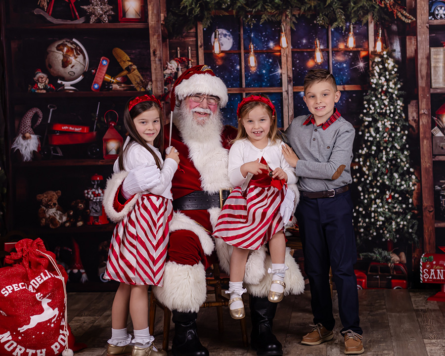 Siblings smiling with Santa during thier private Santa Photo session in Raleigh North Carolina