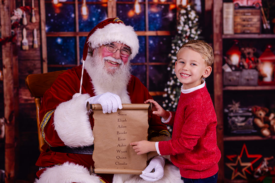 boy in Raleigh north carolina pointing to Santa's Nice list