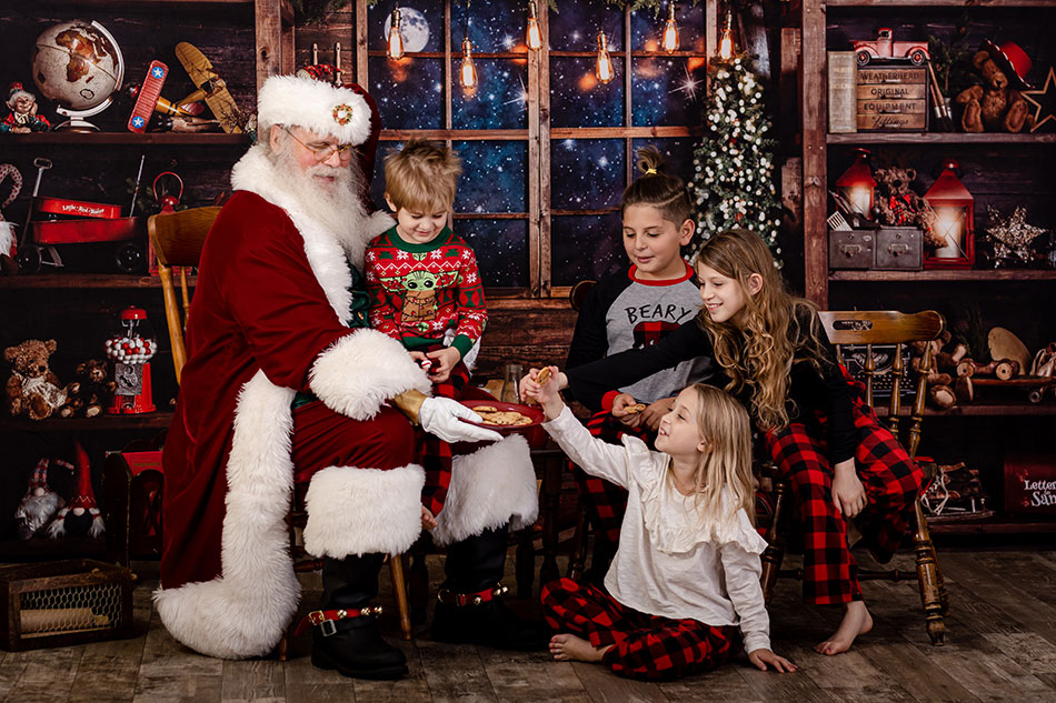 group of siblings sharing cookies with santa claus in Raleigh North Carolina