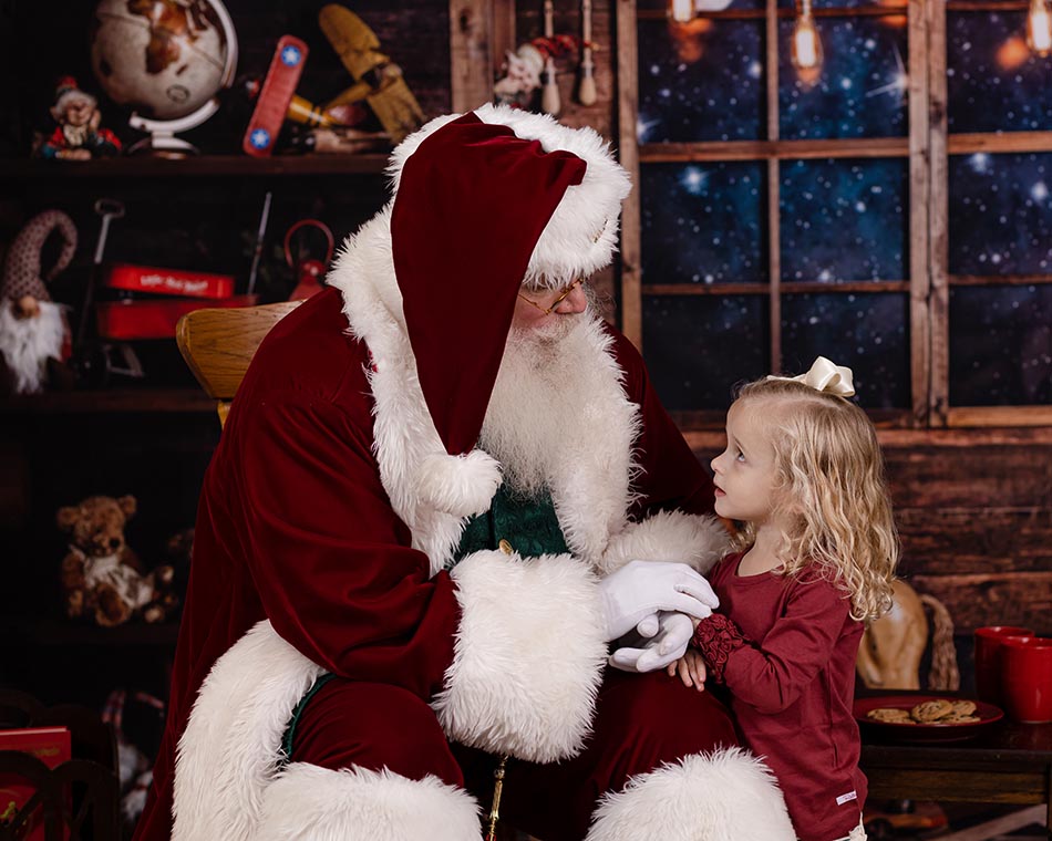 little girl looking at Santa during her photo session Raleigh NC with a private Santa photo appointment